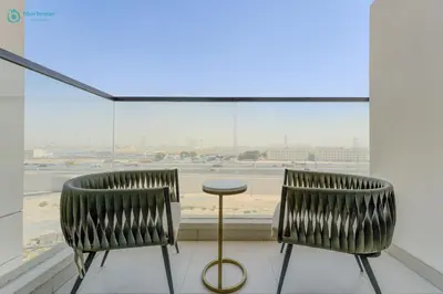 two chairs and a table in front of a window at Bright & Luxury Studio with Balcony in Al Furjan in Dubai