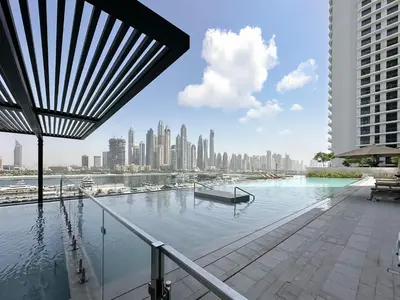 a swimming pool with a view of a city at Seaside Elegance 1BR Luxury Apartment with Private Beach Access, Emaar Beachfront in Dubai