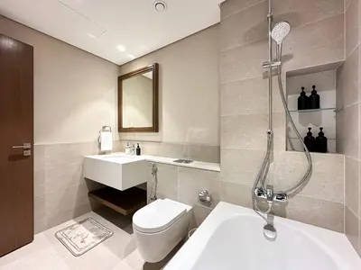 a bathroom with a shower and a toilet and a sink at Seaside Elegance 1BR Luxury Apartment with Private Beach Access, Emaar Beachfront in Dubai