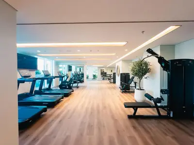 a gym with a row of treadmills and benches at ALiving Classy 1BR I Stunning Views I Emaar Palace Beach Residence in Dubai