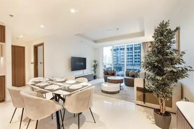 a living room with a table and chairs and a couch at ALiving Classy 1BR I Stunning Views I Emaar Palace Beach Residence in Dubai