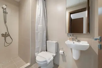 a bathroom with a toilet and a sink and a shower at 2BR Canal Front B3, Waterfront Views in Dubai