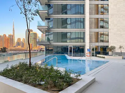 a large building with a swimming pool in front of it at 2BR Canal Front B3, Waterfront Views in Dubai