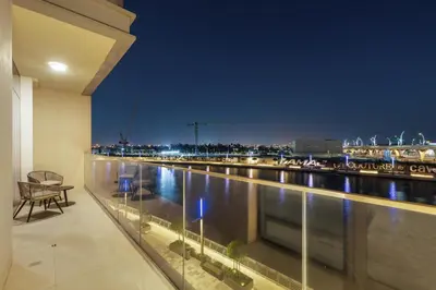 a balcony with a view of a river at night at 2BR Canal Front B3, Canal Views in Dubai