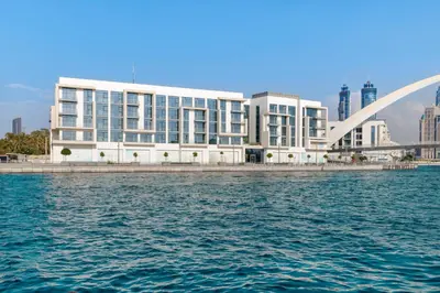 a large white building next to a body of water at 2BR Canal Front B3, Canal Views in Dubai