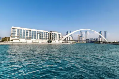 a bridge over the water in front of a building at 2BR Canal Front B3, Canal Views in Dubai