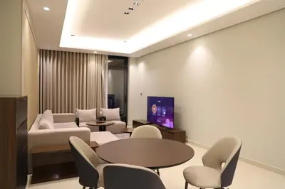 a living room with a couch and a table and chairs at Brand New Large 2 Bedroom with Burj Khalifa view in Dubai