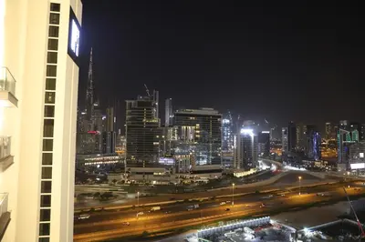 a view of a city at night with traffic at Brand New Large 2 Bedroom with Burj Khalifa view in Dubai
