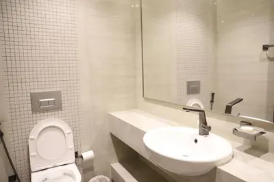 a bathroom with a white toilet and a sink at Brand New Large 2 Bedroom with Burj Khalifa view in Dubai