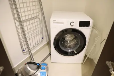 a washing machine sitting next to a washer at Brand New Large 2 Bedroom with Burj Khalifa view in Dubai