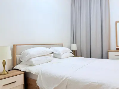a bedroom with a white bed with white sheets and pillows at One bedroom Full view Dubai Hills in Dubai