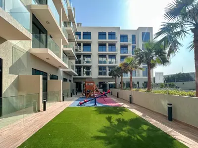 a playground in front of a building with palm trees at Holiday Boulevard - Stylish Upgraded Studio - Designer Touches in JVC in Dubai