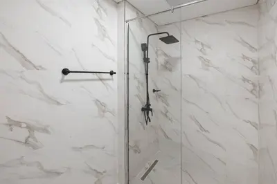 a shower with a glass door in a bathroom at Holiday Boulevard - Stylish Upgraded Studio - Designer Touches in JVC in Dubai