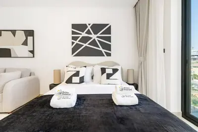 a bedroom with a bed with two pillows on it at Holiday Boulevard - Stylish Upgraded Studio - Designer Touches in JVC in Dubai