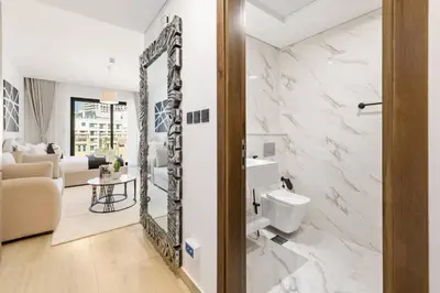 a bathroom with a toilet and a mirror at Holiday Boulevard - Stylish Upgraded Studio - Designer Touches in JVC in Dubai
