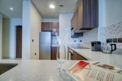 a kitchen with a wine glass sitting on a counter at Luxurious 1BR in Palm View with Palm Jumeirah Views in Dubai