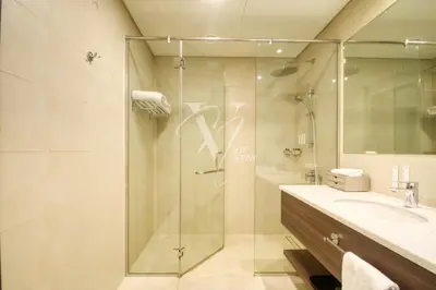 a bathroom with a glass shower and a sink at Luxurious 1BR in Palm View with Palm Jumeirah Views in Dubai