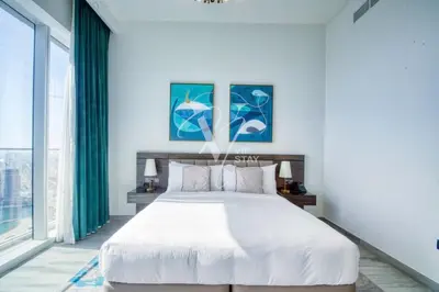 a bedroom with a large bed and a large window at Luxurious 1BR in Palm View with Palm Jumeirah Views in Dubai