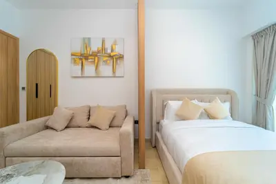 a bedroom with a couch and a bed and a chair at Elegant JVC Stay Luxury Amid Nature in Dubai