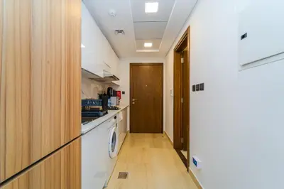 a kitchen with a washer and dryer in a room at Elegant JVC Stay Luxury Amid Nature in Dubai