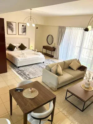 a living room with a couch and a bed at Beachside Spacious Studio at the heart of JBR in Dubai