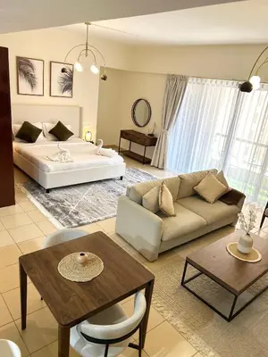 a living room with a couch and a bed at Beachside Spacious Studio at the heart of JBR in Dubai