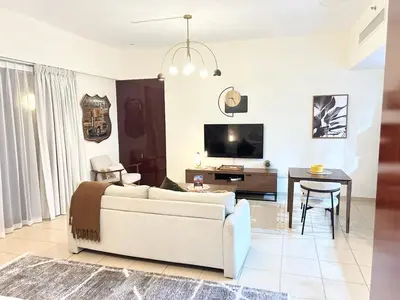 a living room with a couch and a table at Beachside Spacious Studio at the heart of JBR in Dubai