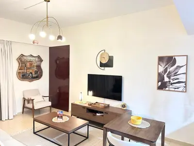 a living room with a television and a table at Beachside Spacious Studio at the heart of JBR in Dubai