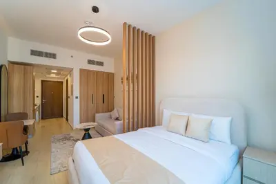 a bedroom with a large white bed and a chair at Luxurious Nature with 5 Star Amenities in JVC in Dubai