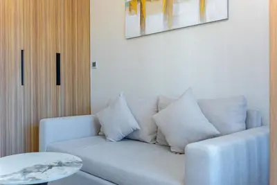 a living room with a white couch and a table at Luxurious Nature with 5 Star Amenities in JVC in Dubai