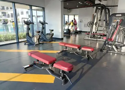 a gym with cardio equipment and red chairs in it at The Nook 2 - 2 bed flat near Dubai Marina in Dubai
