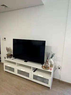 a flat screen tv sitting on top of a white entertainment center at The Nook 2 - 2 bed flat near Dubai Marina in Dubai