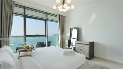 a bedroom with a white bed and a large window at Luxury 2BR, Panoramic Sea Views and Beach Access in Dubai