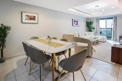 a dining room and living room with a table and chairs at 13P-Sea View Apartment in Dubai Marina with Pool & Balcony in Dubai