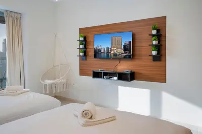 a room with a tv on a wall with a bed at 13P-Sea View Apartment in Dubai Marina with Pool & Balcony in Dubai