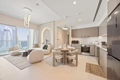 a kitchen and living room with a table and chairs at Elite Escapes - 2 BHK Luxurious - Grande Signature in Dubai