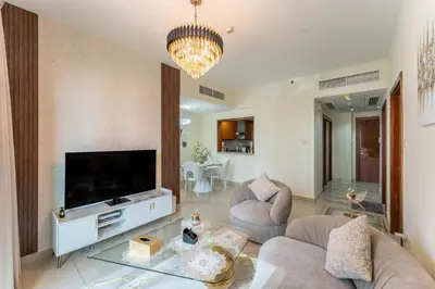 a living room with a large television and a couch at Stand Point Residence by Hogar in Dubai