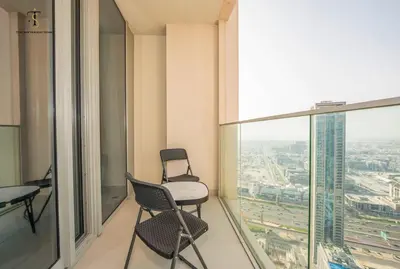 an empty room with a chair and a window at Swanky Suite Forte T1 2BR Downtown in Dubai