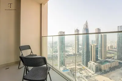 a room with two chairs in front of a large window at Swanky Suite Forte T1 2BR Downtown in Dubai