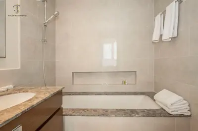 a bathroom with a bath tub and a sink at Swanky Suite Forte T1 2BR Downtown in Dubai