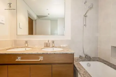 a bathroom with two sinks and a tub and a shower at Swanky Suite Forte T1 2BR Downtown in Dubai