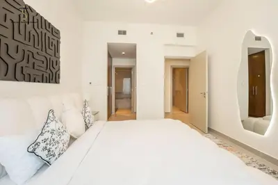 a white bedroom with a white bed and a mirror at Swanky Suite Forte T1 2BR Downtown in Dubai