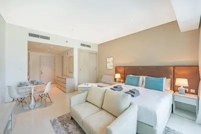 a bedroom with a large bed and a couch at Spacious Studio Beach Access Seven Palm Dubai in Dubai