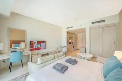 a large living room with a white couch and a table at Spacious Studio Beach Access Seven Palm Dubai in Dubai