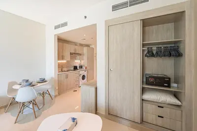 a kitchen with a door that has a microwave on it at Spacious Studio Beach Access Seven Palm Dubai in Dubai