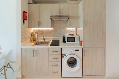 a kitchen with a washing machine and a sink at Spacious Studio Beach Access Seven Palm Dubai in Dubai