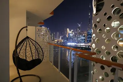 a balcony with a view of a city at night at Luxury 1BR Apartment with Burj Khalifa&Canal view in Dubai