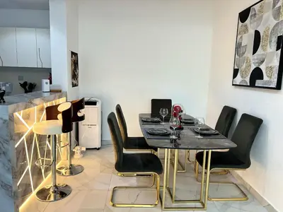 a dining room with a table and black chairs at Luxury 1BR Apartment with Burj Khalifa&Canal view in Dubai