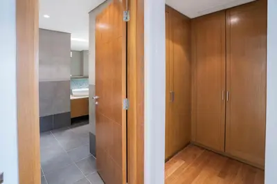 a walk in closet with wooden cabinets in a bathroom at PJ- Premium Palm Jumeirah Apartment - Beachfront, Pool & Balcony in Dubai