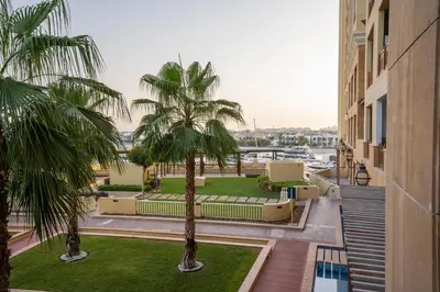 a view of a courtyard with palm trees and a building at PJ- Premium Palm Jumeirah Apartment - Beachfront, Pool & Balcony in Dubai
